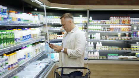 A-middle-aged-visitor-in-a-grocery-store-chooses-milk-products