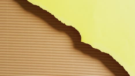 video of close up of torn pieces of yellow and brown striped paper background