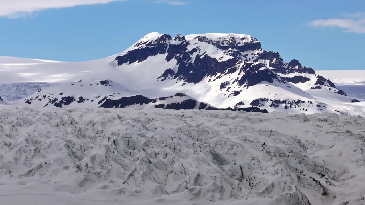 Drone parallax of rugged Hoffellsjökull glacier and snow covered mountain behind