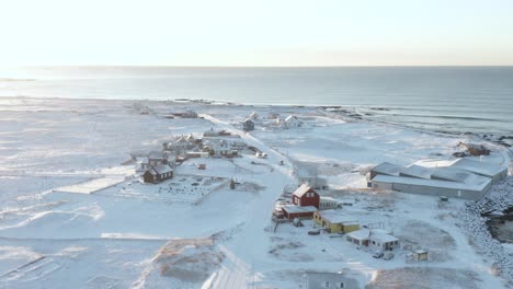 ciudad rural hafnir en islandia durante la brillante puesta de sol cubierta de nieve invernal, aérea