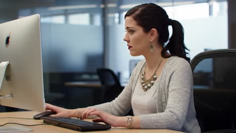 focused young professional engaged in work at a modern office desk, utilizing computer while enhancing productivity and concentration levels in a stylish environment