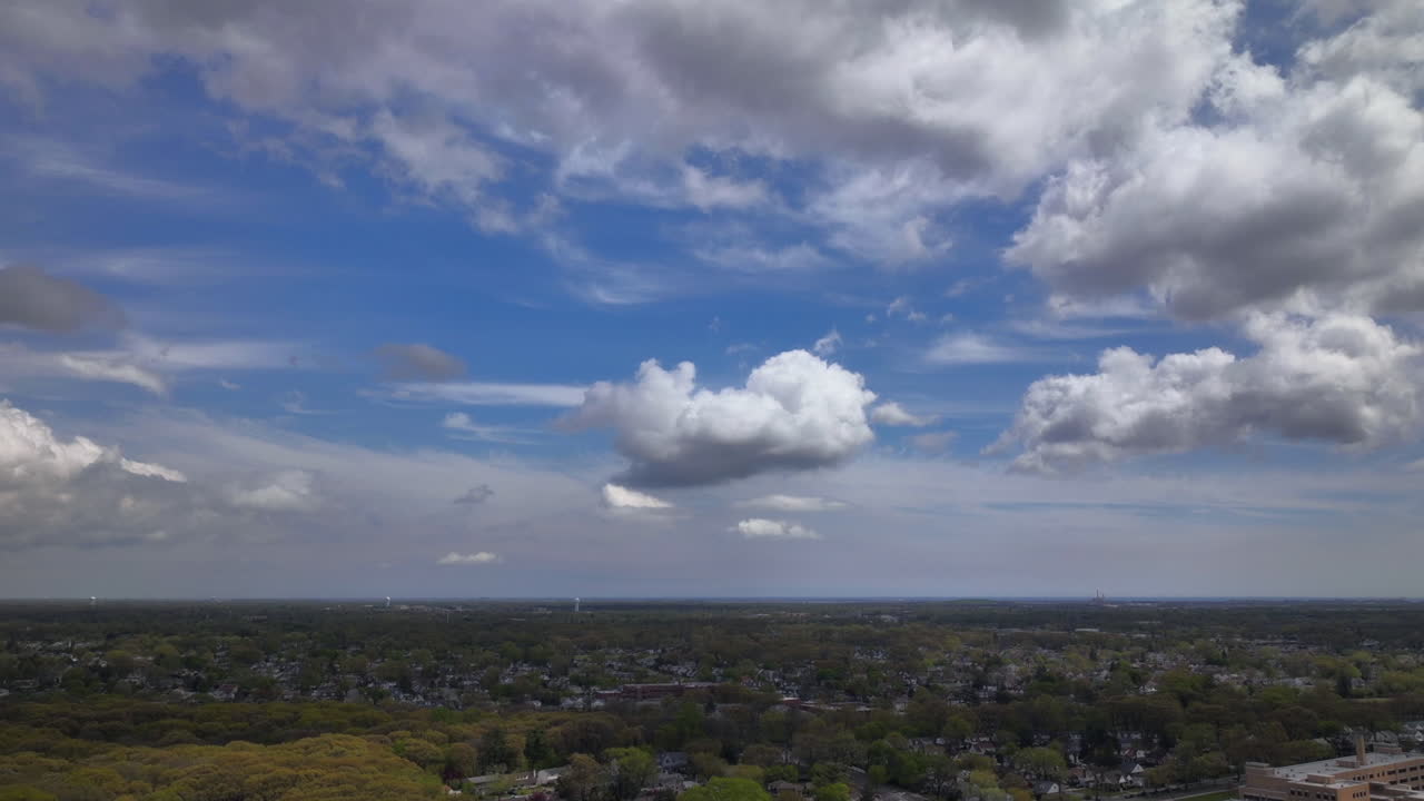 un lapso de tiempo aéreo sobre un barrio residencial en long island, nueva york en un hermoso día con cielos azules y nubes blancas