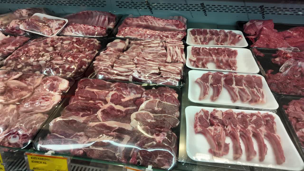 Various cuts of raw meat on display at a grocery store