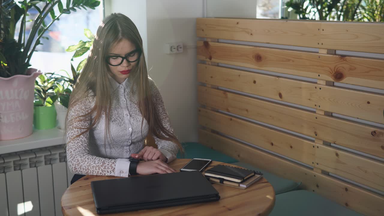 mujer trabajando en una computadora portátil en un café