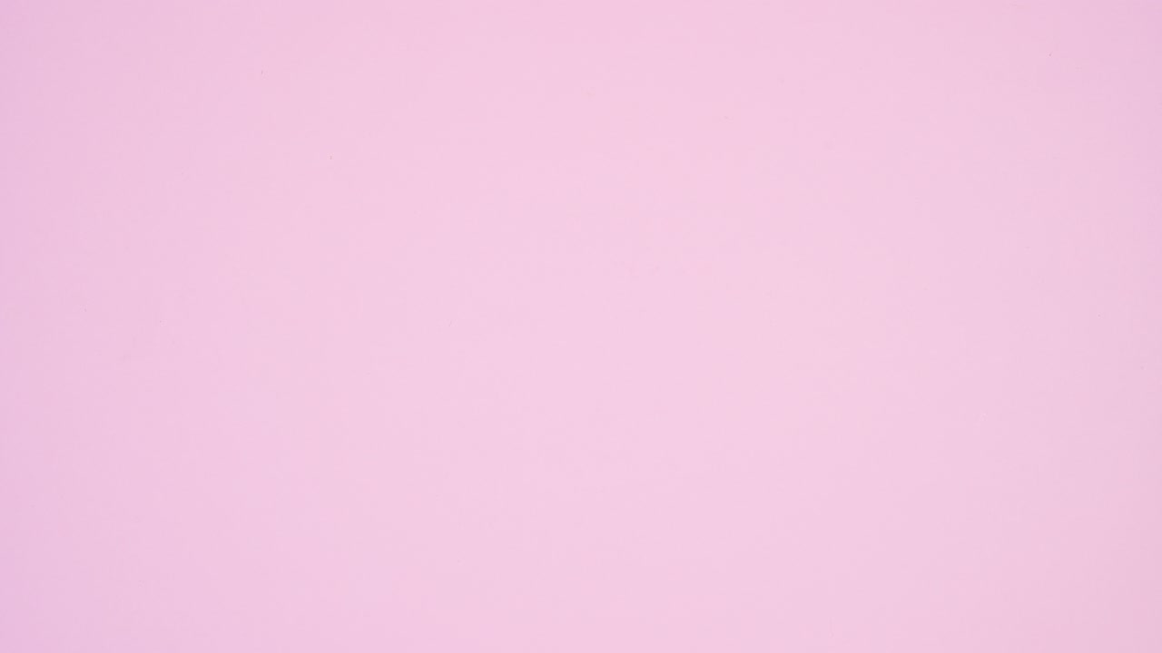 Pastel pink hardcover book appear and other pile of books ordering on it. Stop motion flat lay