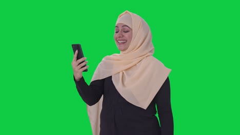 mujer musulmana feliz hablando en video llamada pantalla verde