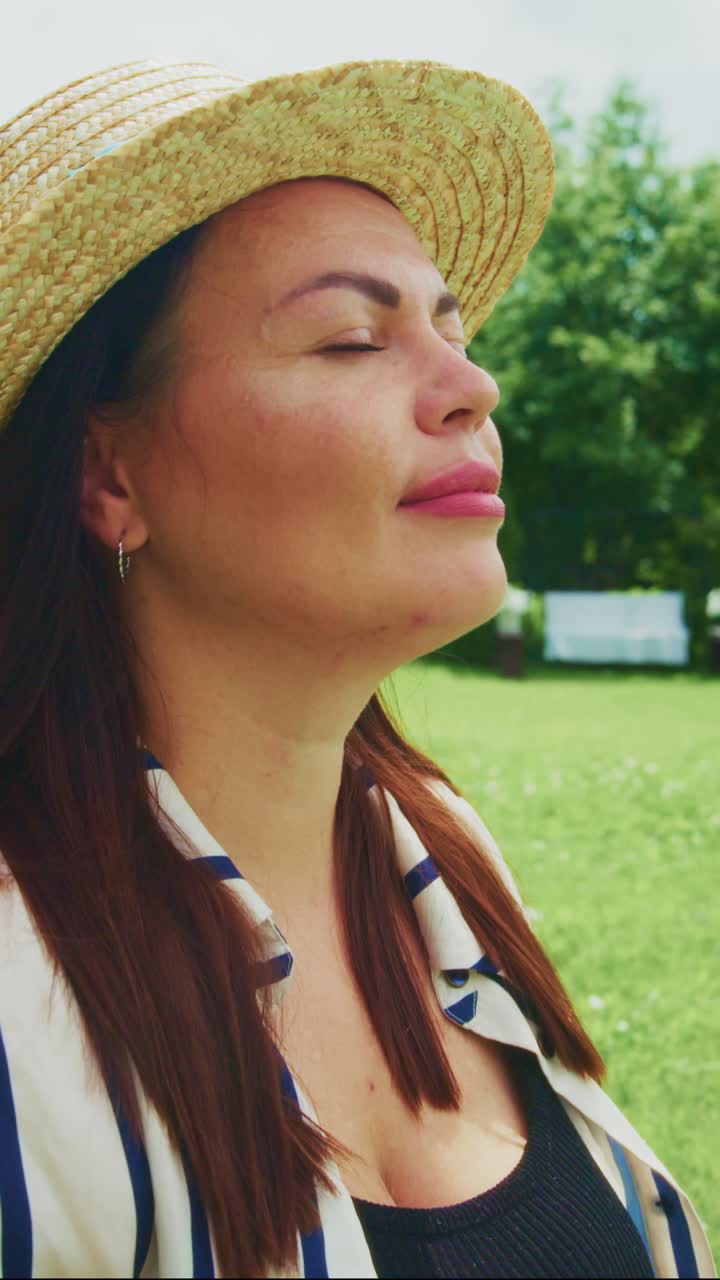 A Serene Moment in Nature: A Woman Enjoys the Sunshine While Practicing Mindfulness in a Vibrant Green Garden Setting