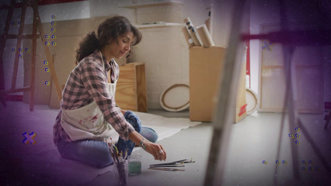 Artista che prende il barattolo dei pennelli, ordinando e sciacquando i pennelli in studio, sovrapposizione viola che guida la preparazione della pittura
