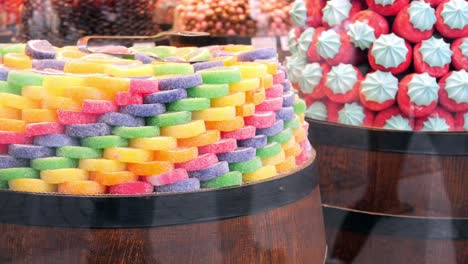 colorful gummy candies in wooden barrels