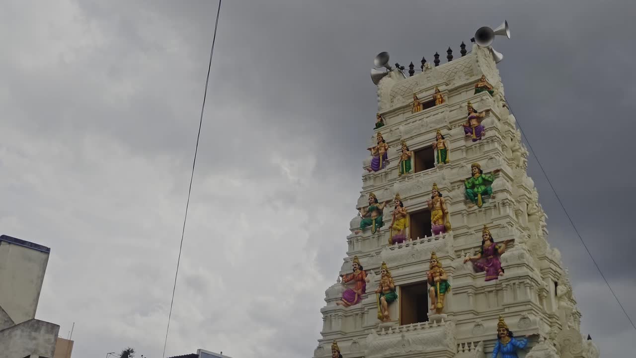 Ramalayam Temple gopuram with loud speakers and rainy clouds at dullapally, hyderabad, telangana, india. day time, stable shot, low angle shot, 4k