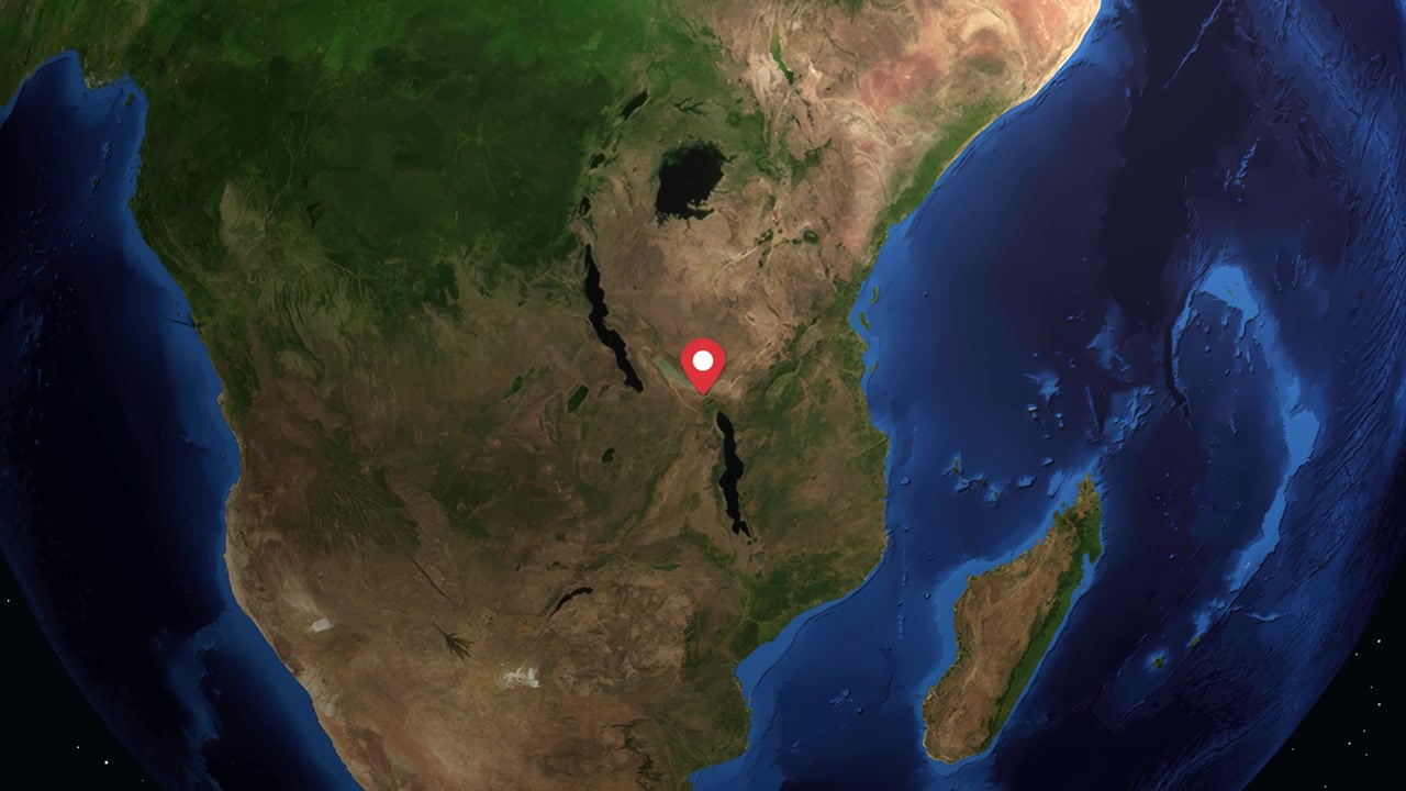 Il globo digitale ruota e ingrandisce sull'Africa orientale, evidenziando Mbeya, Tanzania con informazioni statistiche