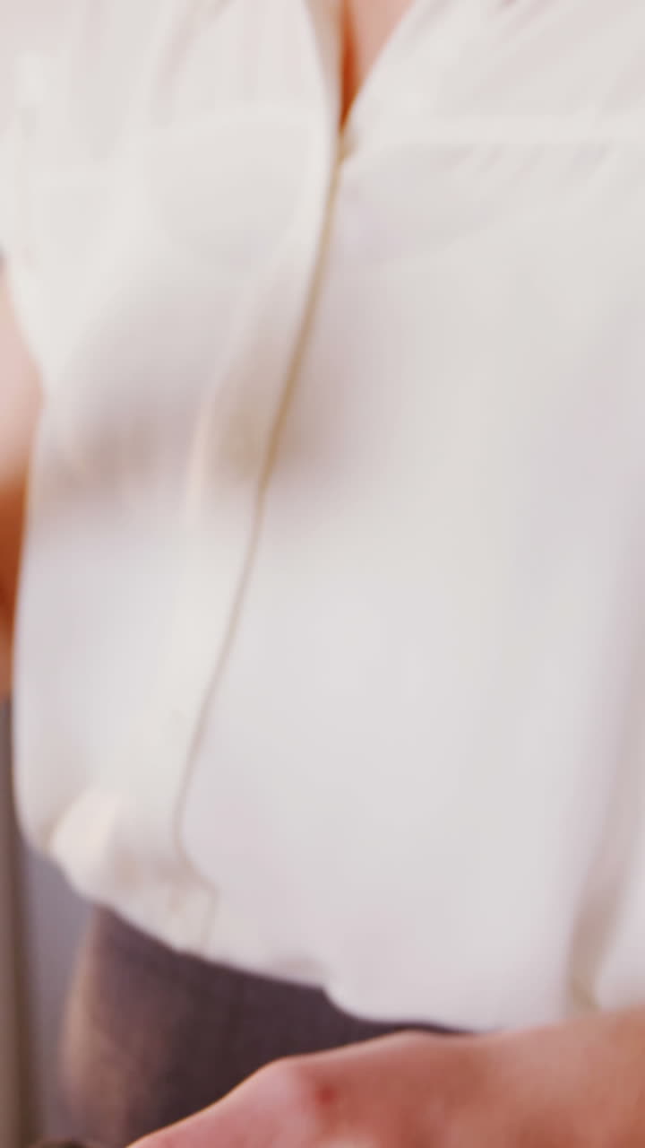 mujer usando teléfono móvil y portátil mientras toma café en la cocina