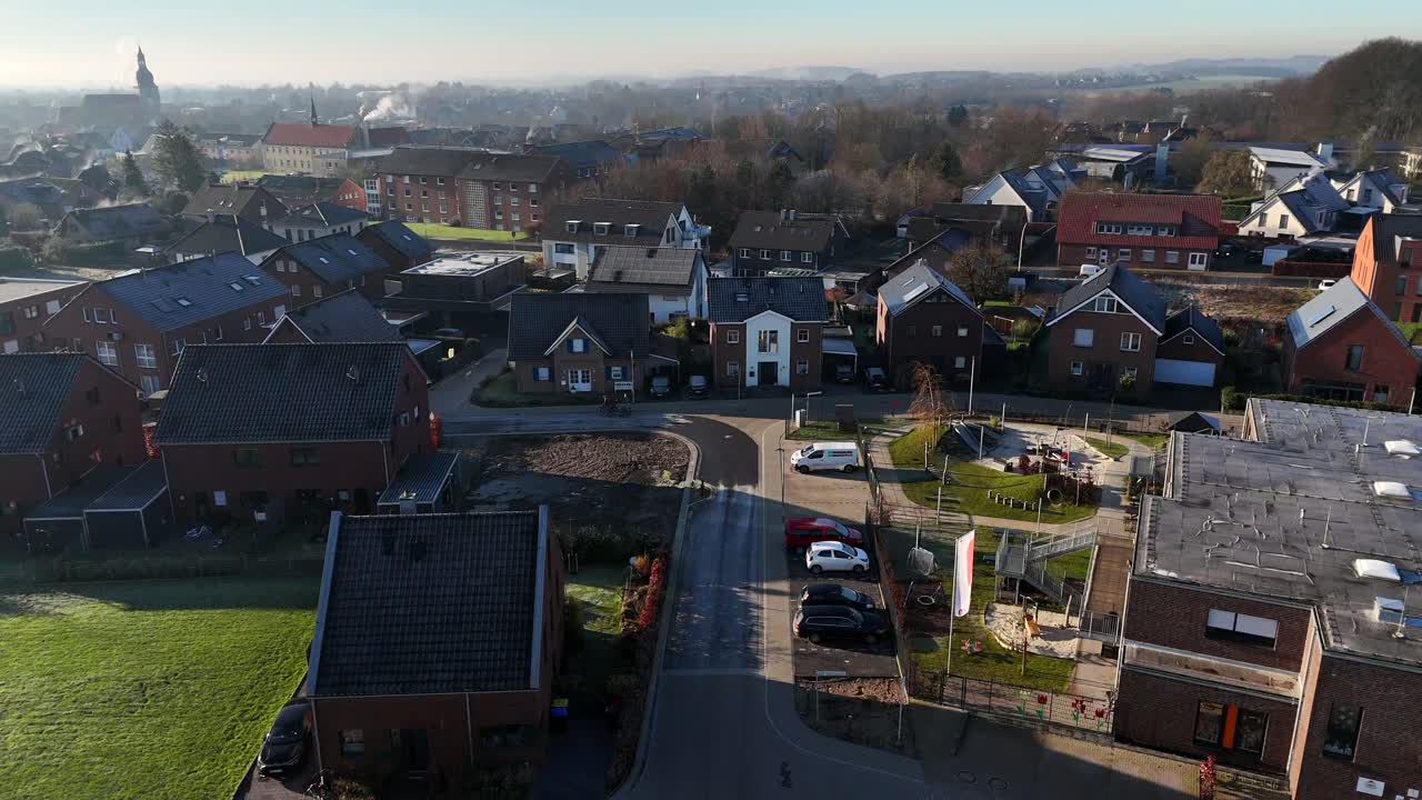 Moderne case unifamiliari con pannelli solari in un quartiere di nuova costruzione. Quartiere suburbano americano con silhouette di chiesa in lontananza. Giornata invernale di sole. Ampia ripresa aerea in avanti