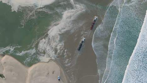 fotografía aérea de arriba hacia abajo de un camión con remolque y atv conduciendo en la playa de pismo california playa de arena al amanecer