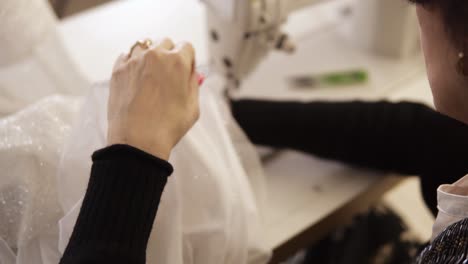 Vista-En-ángulo-Alto-De-La-Máquina-De-Coser,-Costura-De-Hilo-De-Puntada.-Equipo-Para-Coser-Un-Elegante-Vestido-De-Novia.-Sastre-Femenina-Trabajando-A-Mano.