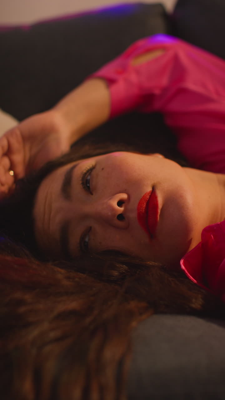 video vertical de cerca de una mujer despertando en el sofá después de beber alcohol en una fiesta de casa sufriendo de resaca