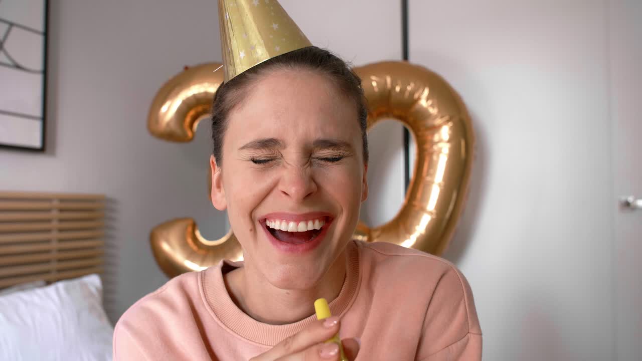 Woman with a party horn blower and party hat