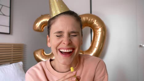 mujer con un soplador de cuerno de fiesta y un sombrero de fiesta