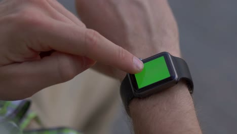 persona que utiliza un reloj inteligente con pantalla verde