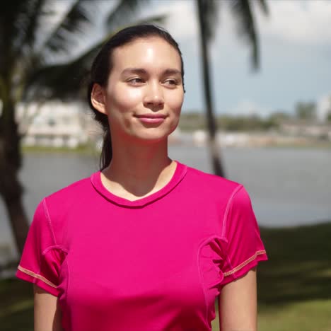 cheerful young woman standing on lakeside