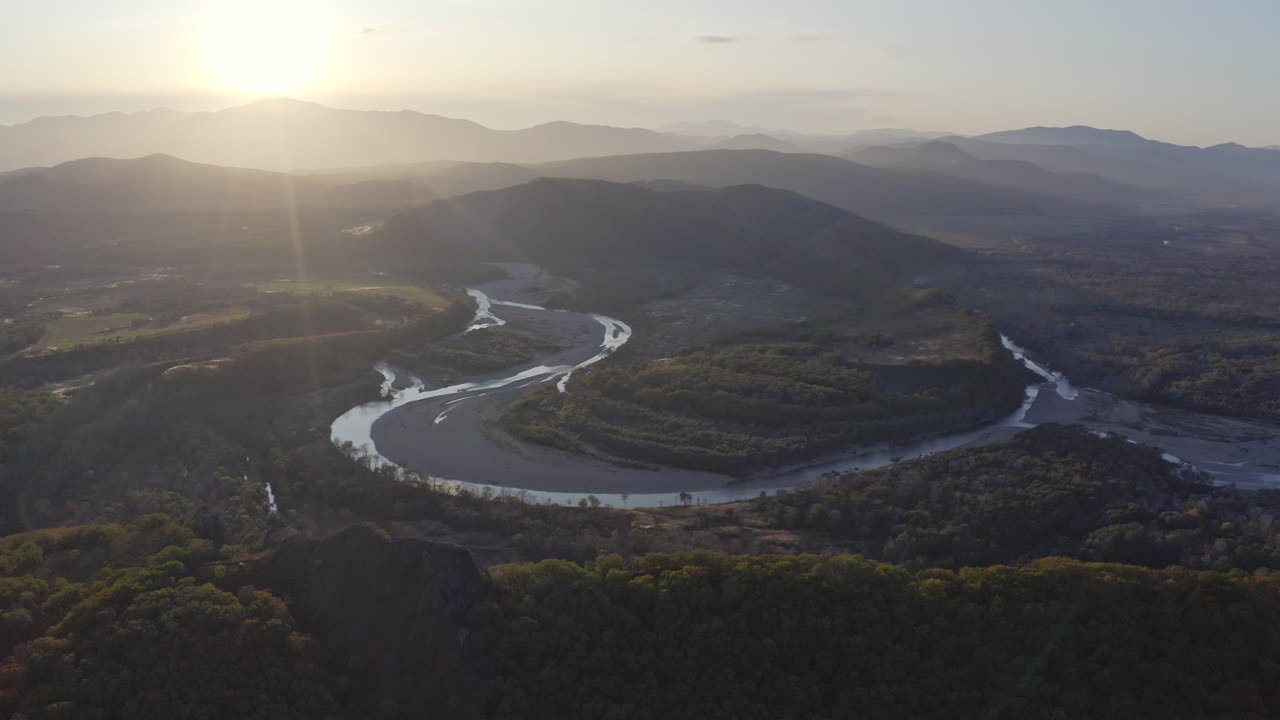 Aerial View of a Meandering River at Sunset in the Mountains