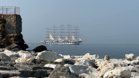 fully rigged all ship slowly lowering sails in mediterranean sea
