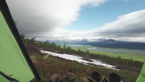 inside of hiking tent with incredible view of stunning lake and mountain and landscape, some hiking shoes in the foreground, camera tracking inside-out, kungsleden trail, northern sweden, lapland