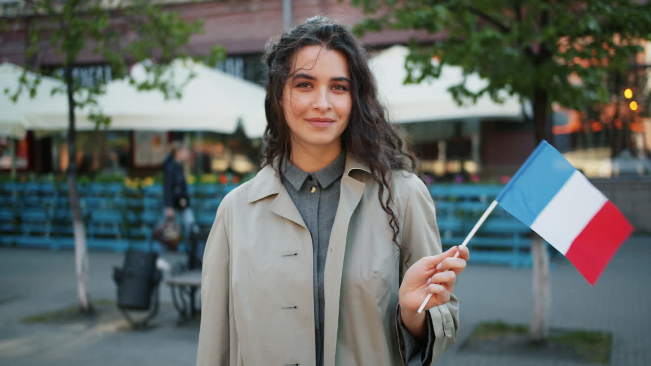 Young woman holding a French flag in a city
