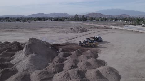 Un-Dron-Captura-A-Una-Retroexcavadora-Recogiendo-Tierra-Y-Arrojándola-A-Un-Camión