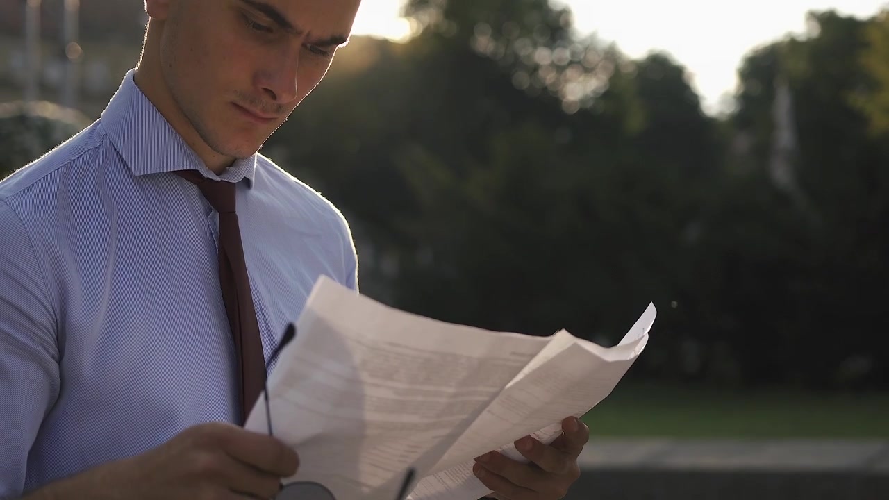 Homem lendo um documento ao ar livre
