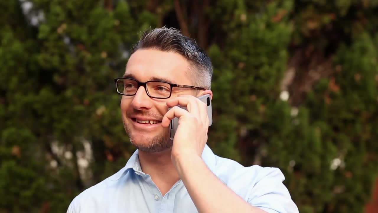 un conferenciante feliz contestando su teléfono.