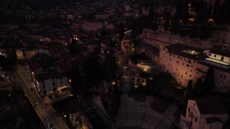 Seitliche-Schwenks-Aus-Der-Luft-Zeigen-Eine-Drohnenaufnahme-Des-Römischen-Theaters-Von-Verona-Bei-Nacht-Und-Der-Glockenturmkathedrale