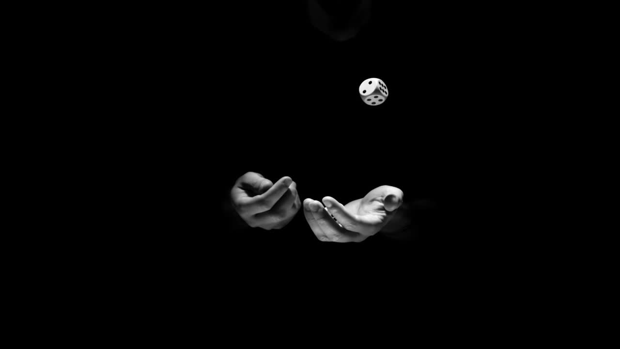 Hands juggling three dice in black and white