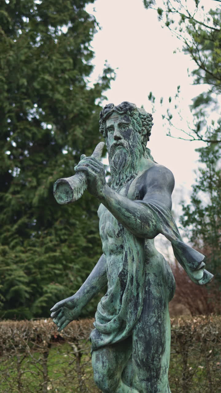 Bronzestatue einer mythischen Figur in einer ruhigen Gartenanlage bei frühem Nachmittagslicht.