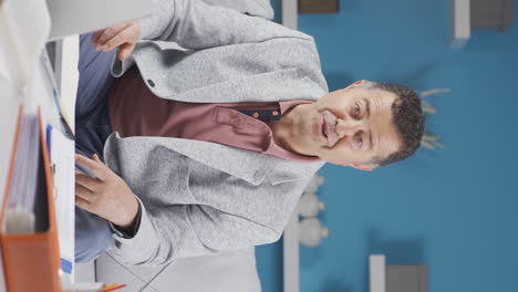 vertical video of home office worker old man says wow to camera.