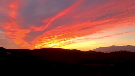 during a bright orange and red sunset in the portuguese mountains it seems as if they are on fire