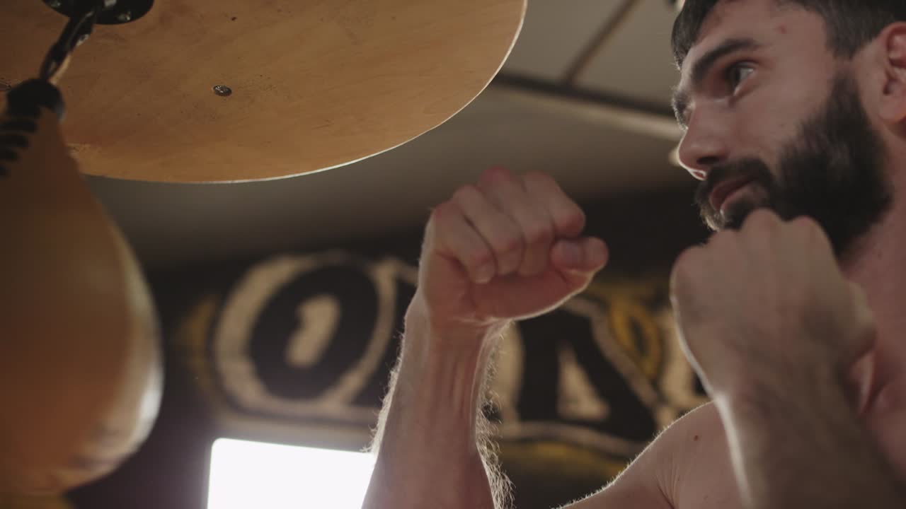 профессиональный боксер бьет с помощью спидбага. кикбоксёр тренируется в спортзале