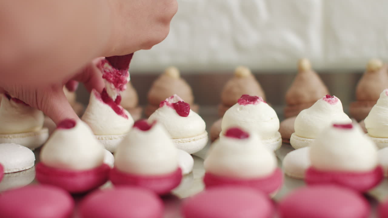 A pastry chef decorates macarons