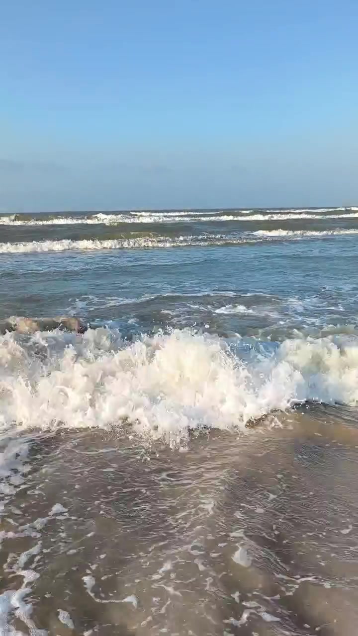 Dolci onde dell'oceano che si infrangono su una spiaggia sabbiosa.
