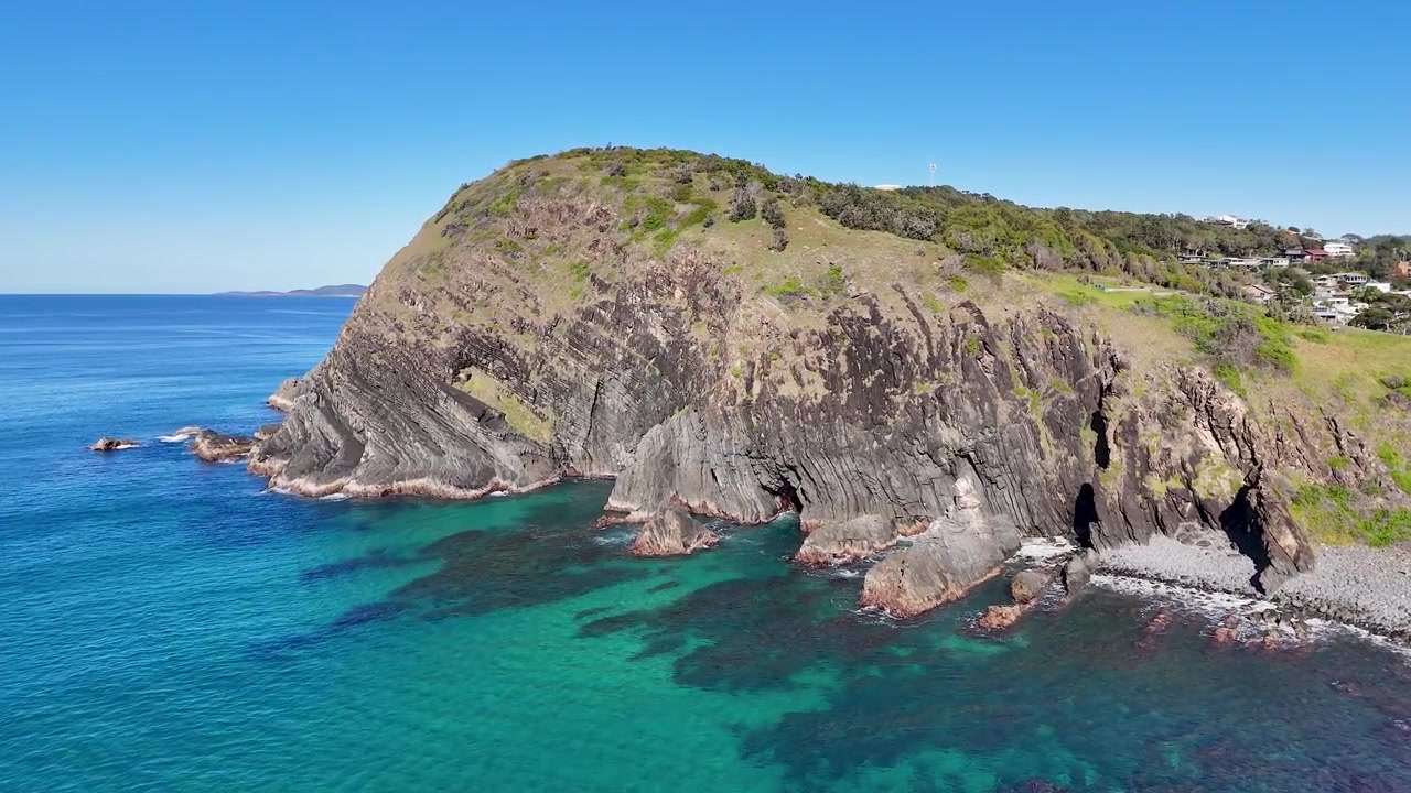 New South Wales, Crescent Head'de kayalık burun ve berrak mavi suyun drone çekimi