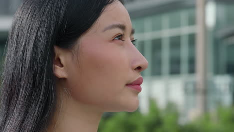 thoughtful young asian woman in urban setting