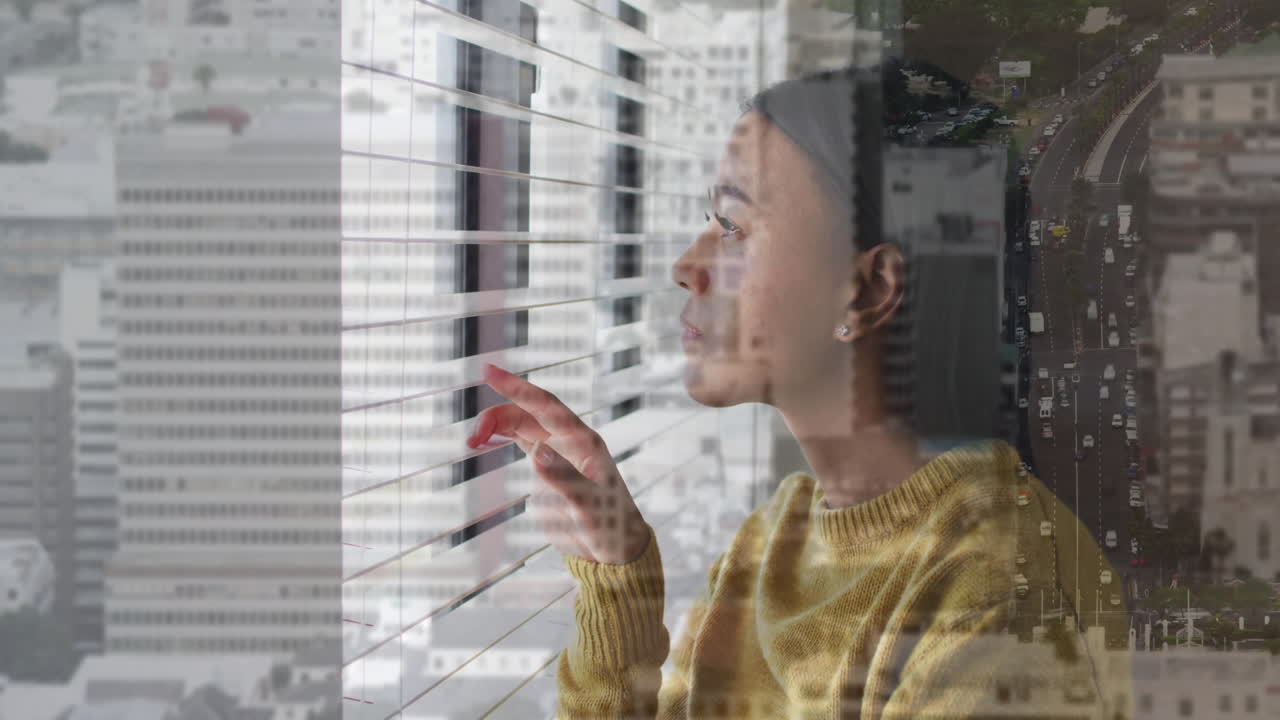 Looking through blinds, woman with cityscape animation overlay on window