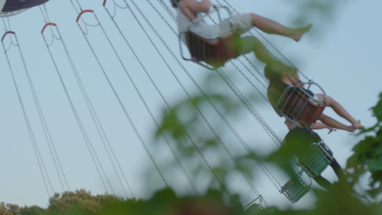 Low angle pov of people having fun on chairoplane carousel