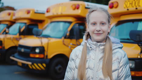 retrato de un niño contra el fondo de una serie de autobuses escolares