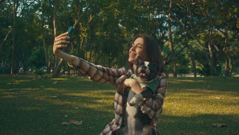 woman taking a selfie with her dog in a park