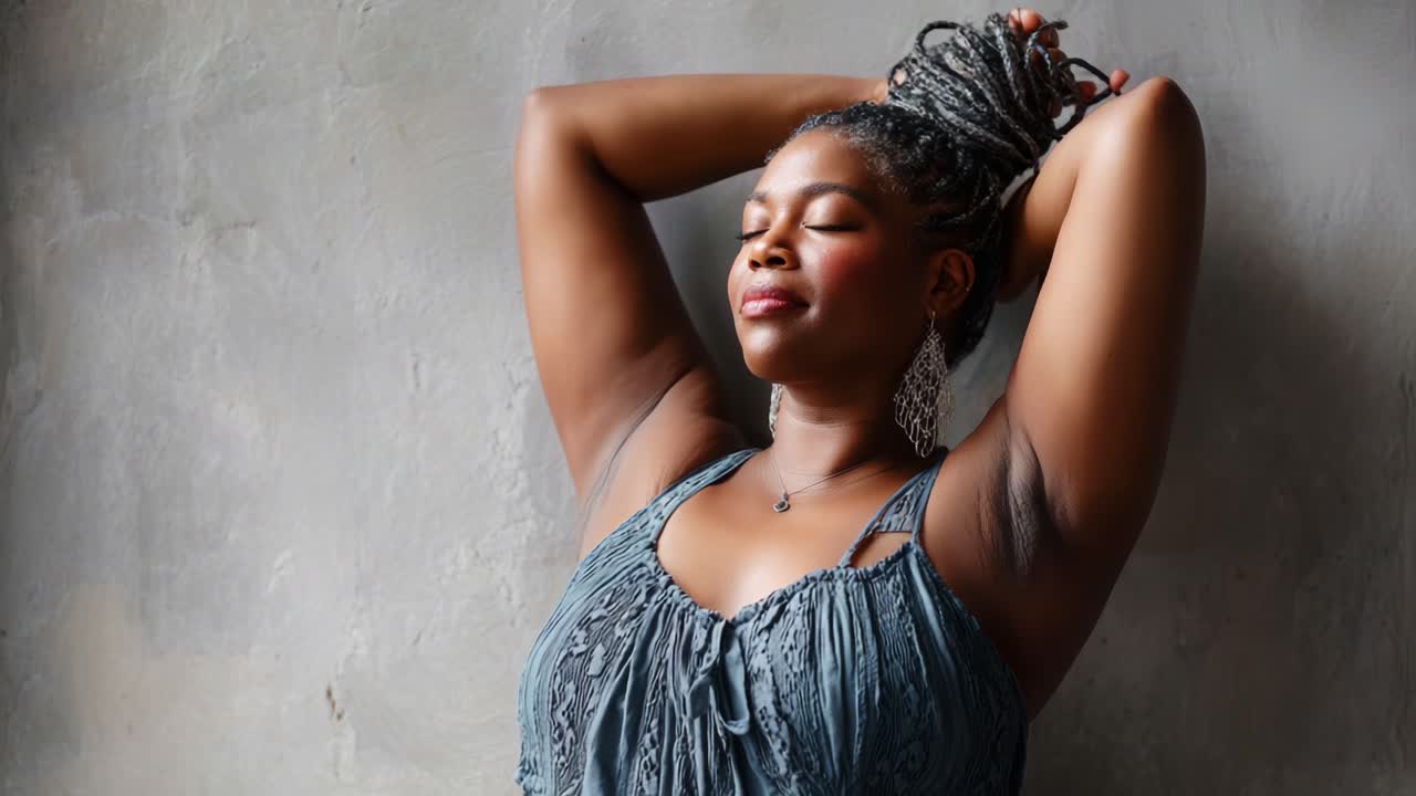 A serene portrait of a confident woman, exuding empowerment and tranquility, as she relaxes against a textured wall, embodying strength and self-acceptance in a moment of quiet reflection