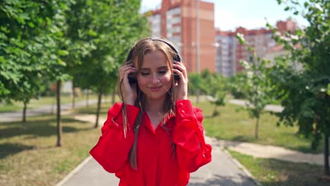 woman listening to music on headphones. young beautiful woman in the city with headphones listening to music
