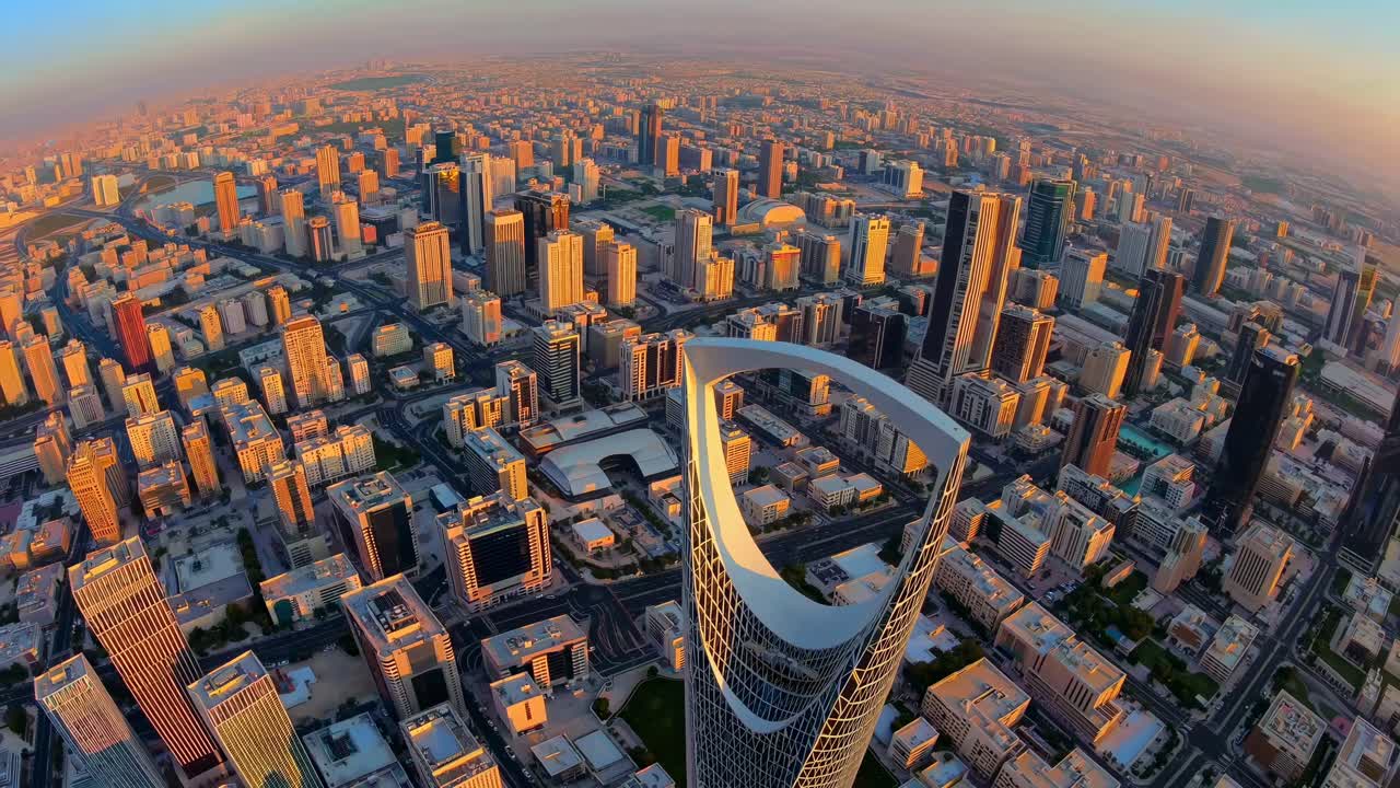 Aerial view of a cityscape at sunset, showcasing modern skyscrapers and urban sprawl