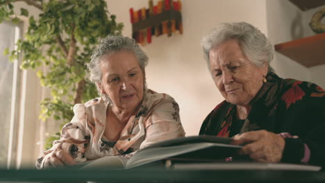 aged women examining photos together