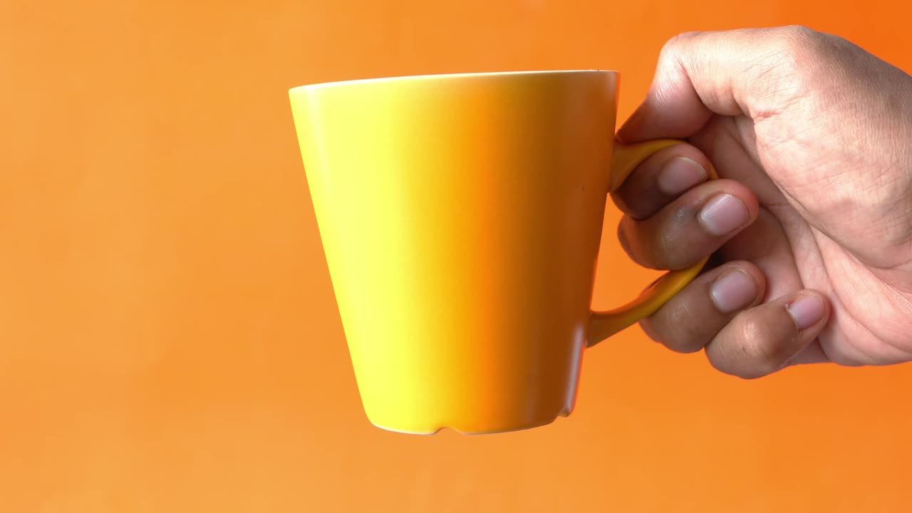 노란 컵을 들고 있는 손